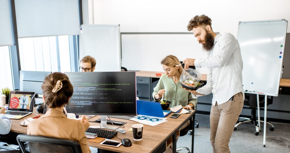 Office,Workers,Eating,Salad,While,Sitting,On,The,Working,Place