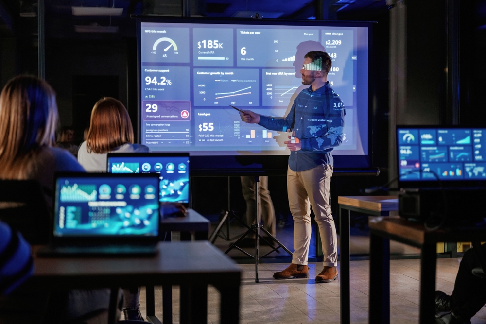 Graph,Is,Going,Up.,Male,Business,Trainer,Is,Against,Projector